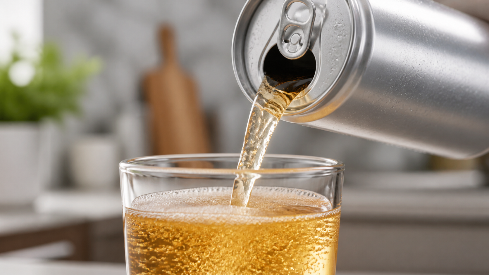 Close-up of open 330ml standard can pouring drink into glass